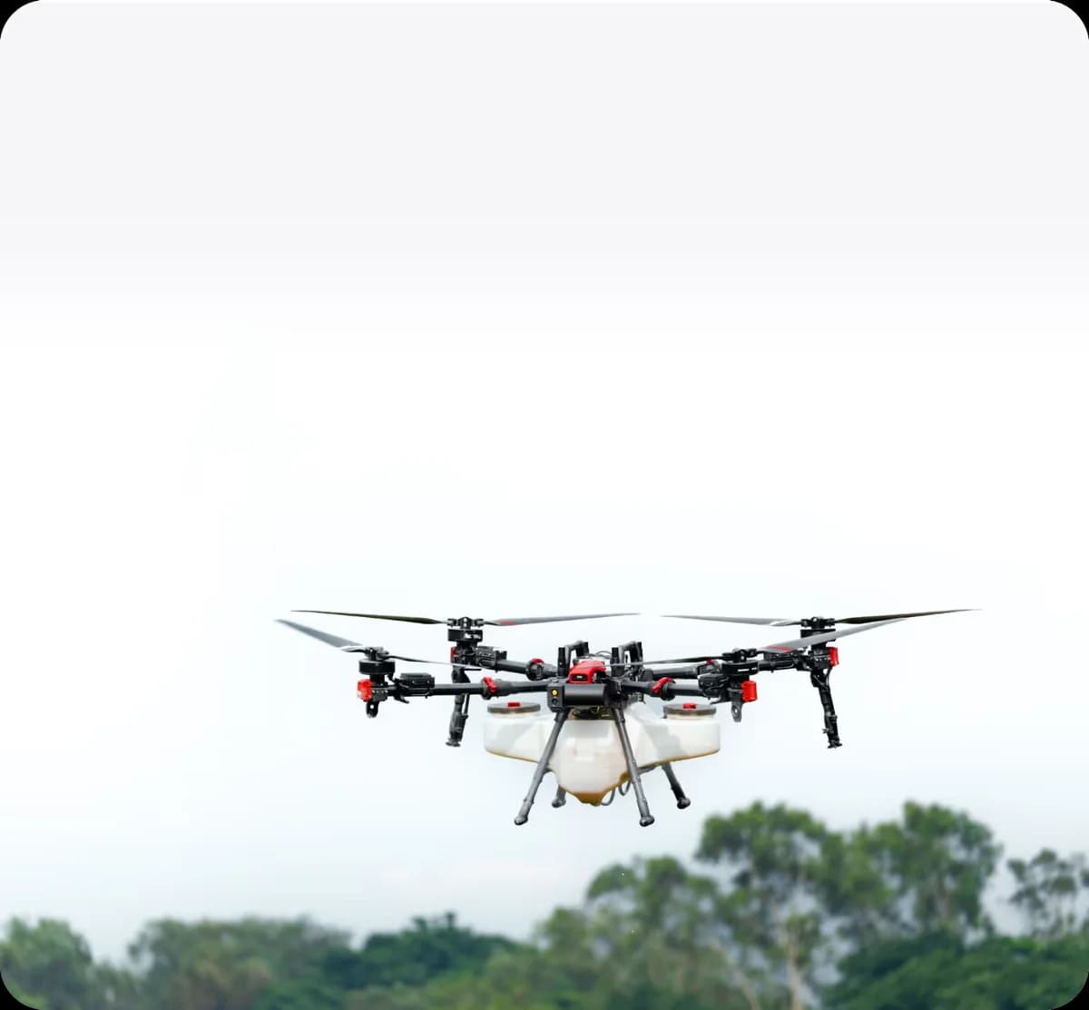XAG P150 agricultural drone flying above trees with its spraying tank