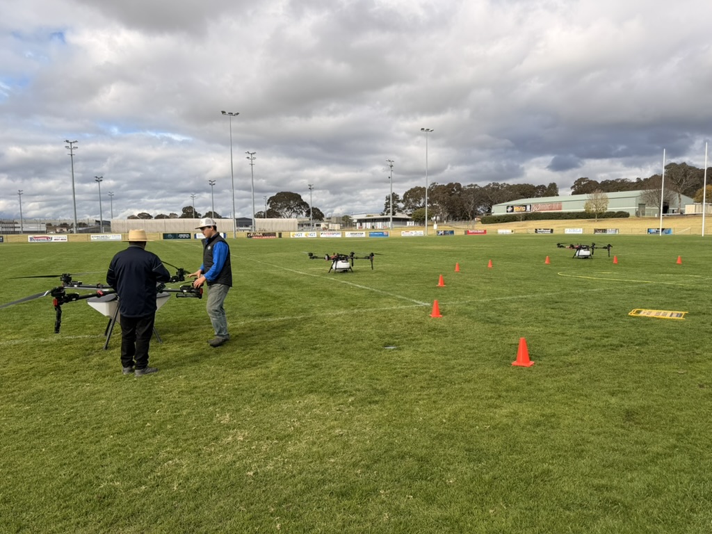 Instructor guiding a student through a practical drone flight course marked with cones