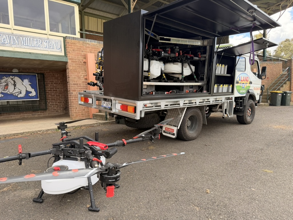 Drone operator loading equipment from a field vehicle
