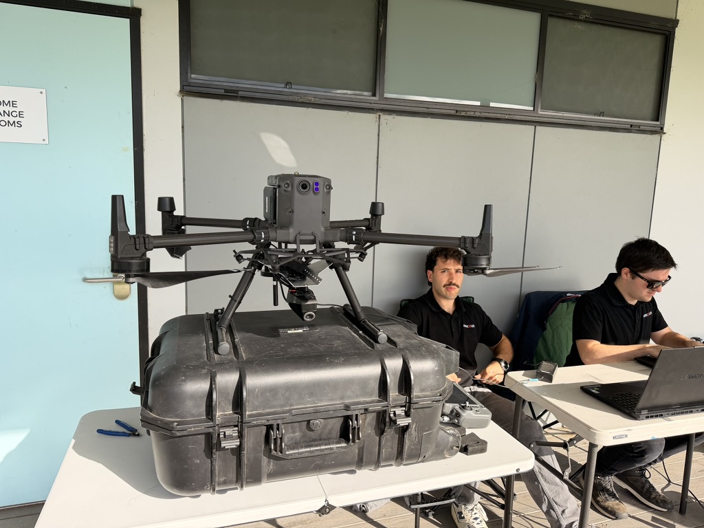 Operators configuring a DJI Matrice M300 drone with laptops before a training flight