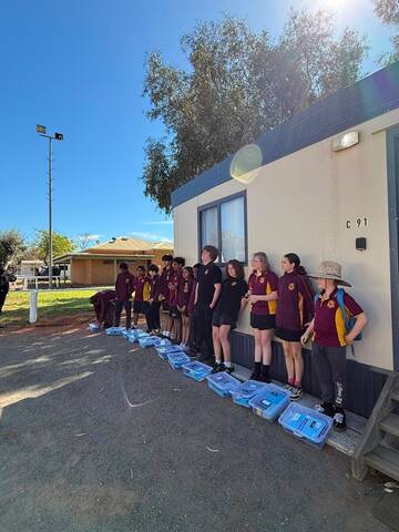 Students lined up with their repair kits outside the classroom