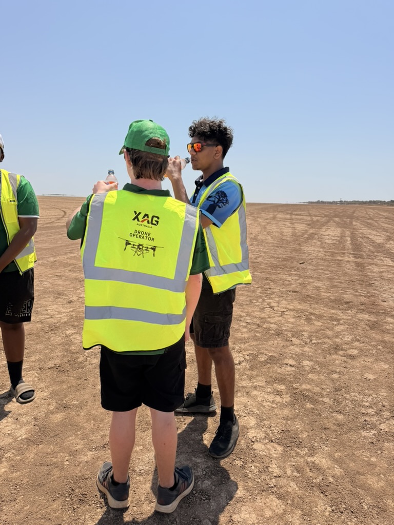 Two pilots in high-visibility vests training together in the field