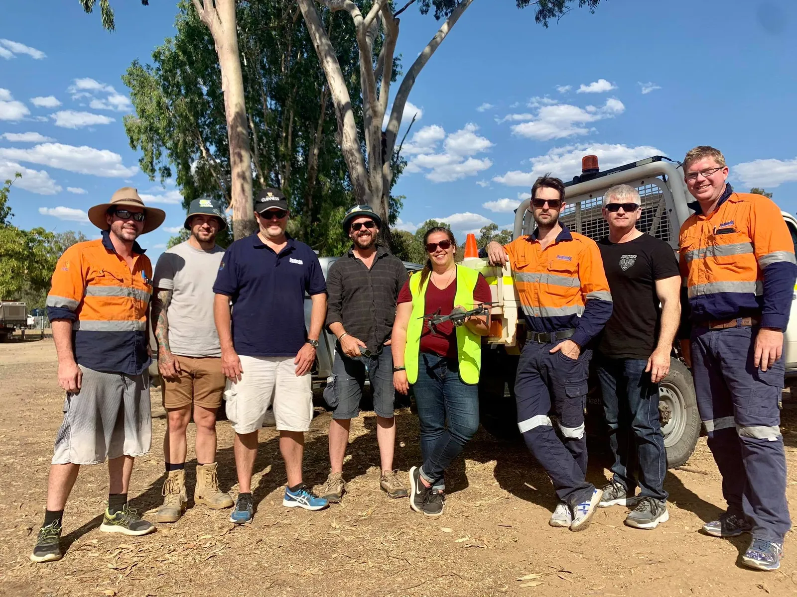 Commercial drone operations team in hi-vis on site with a survey drone