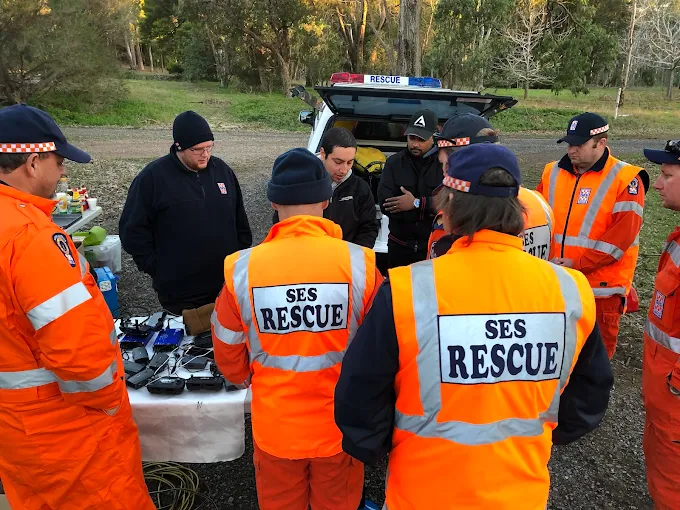 SES Rescue volunteers in hi-vis gathered around drone equipment during a search and rescue field briefing