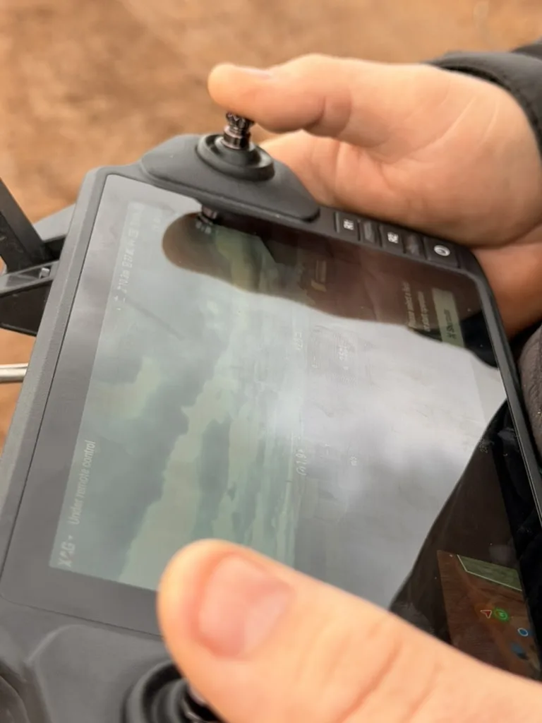 Hands operating an XAG handheld drone controller